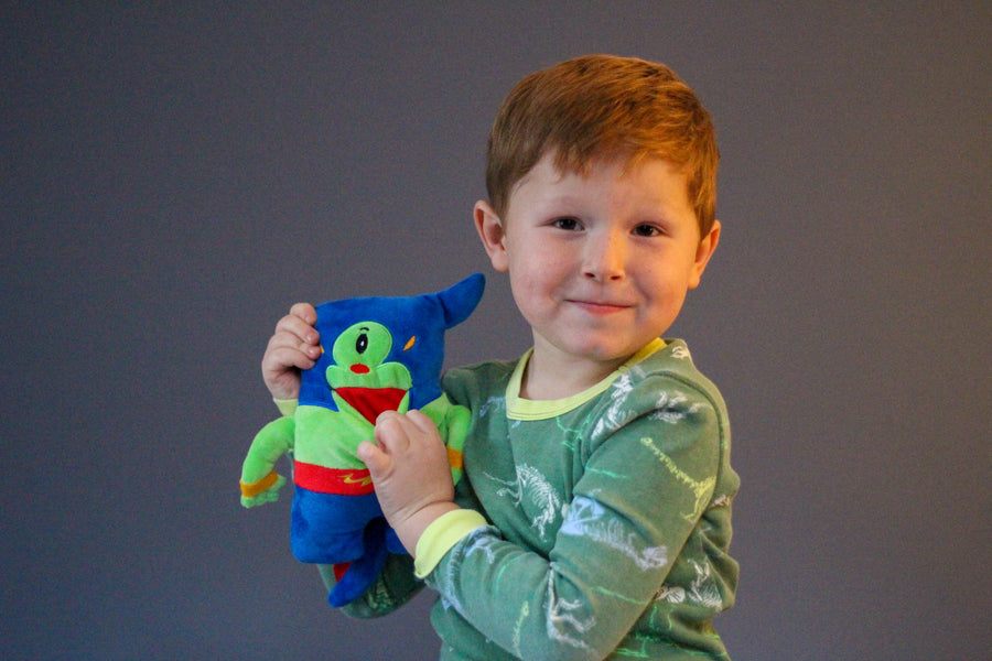 boy holding potato tooth pillow with hand in plushie's mouth