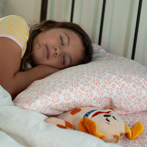 girl is asleep and obi the tooth fairy tooth pillow is under her pillow